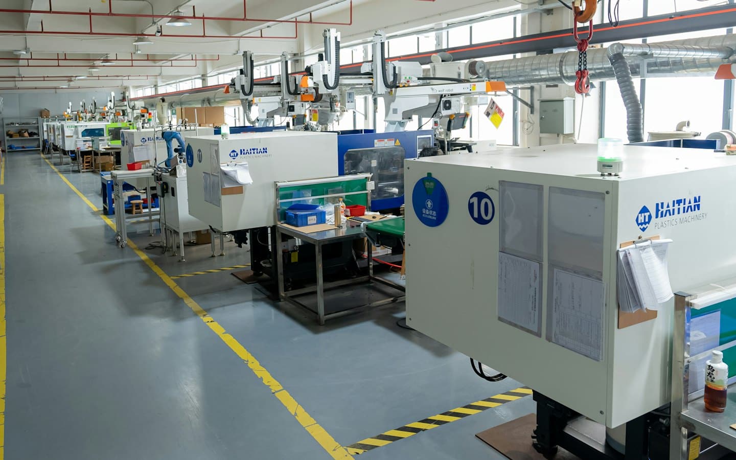 Bracci robotici operano su macchine per lo stampaggio della plastica in una fabbrica.