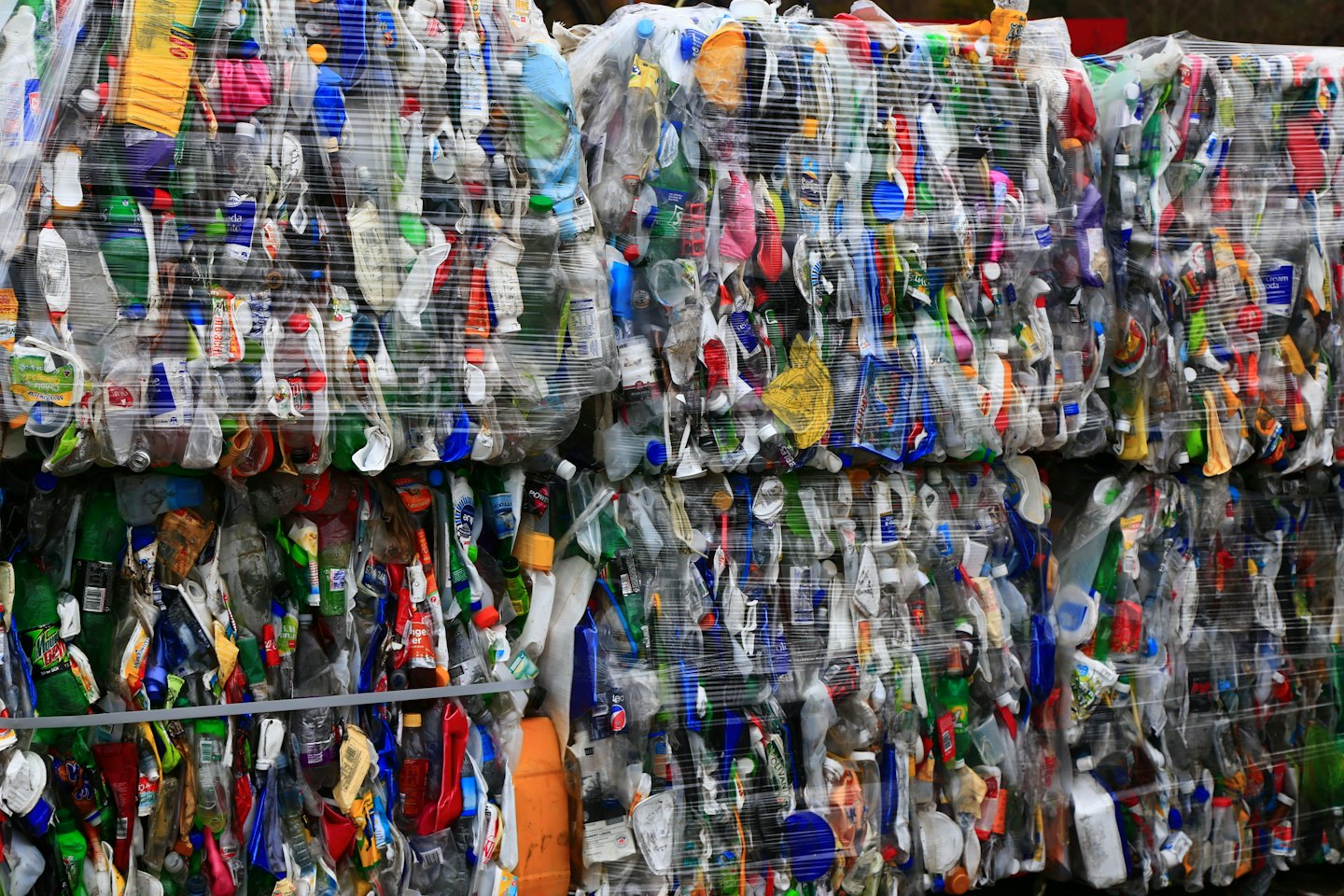 Balle di bottiglie e contenitori di plastica riciclata compressi e colorati.
