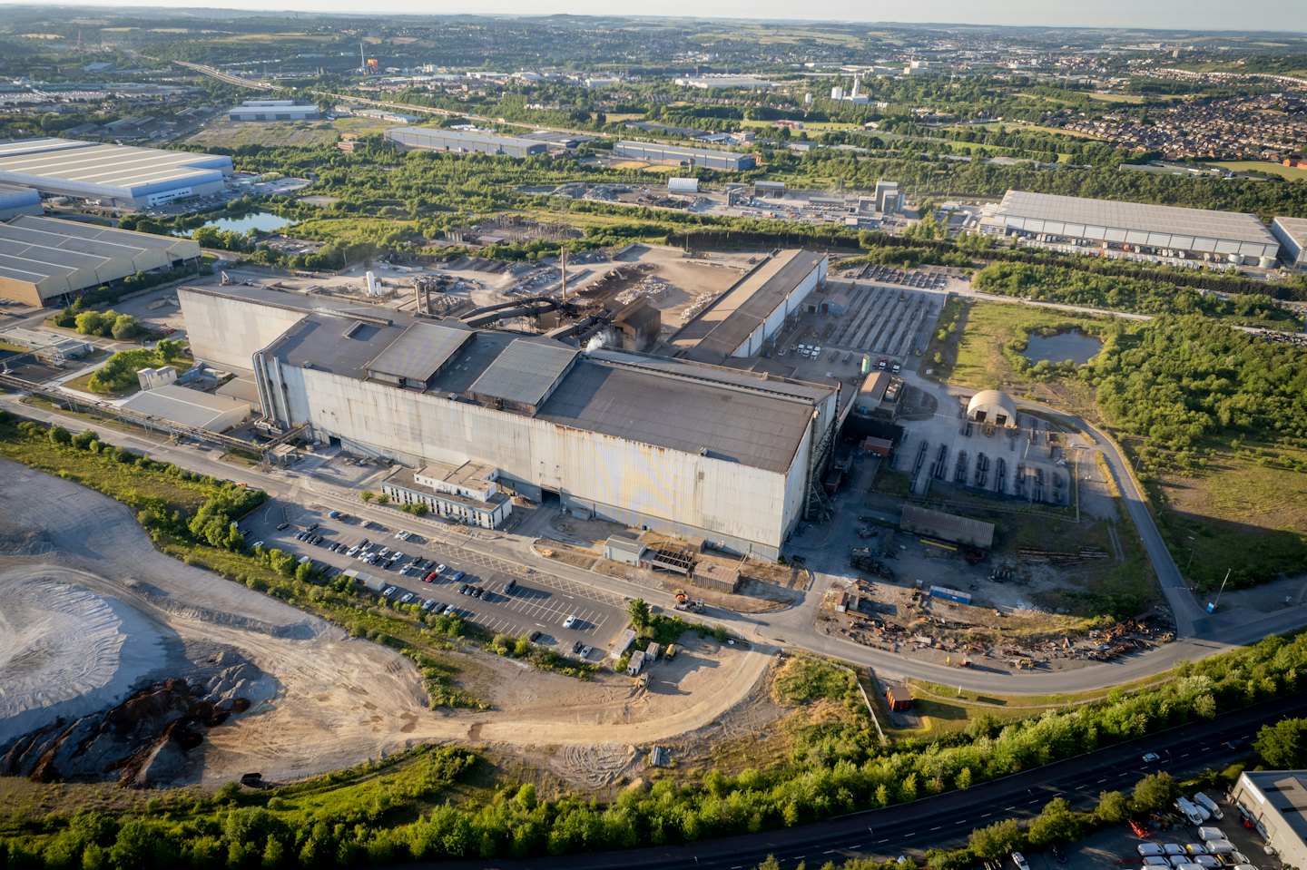 Ampio complesso industriale circondato da verde e parcheggi.