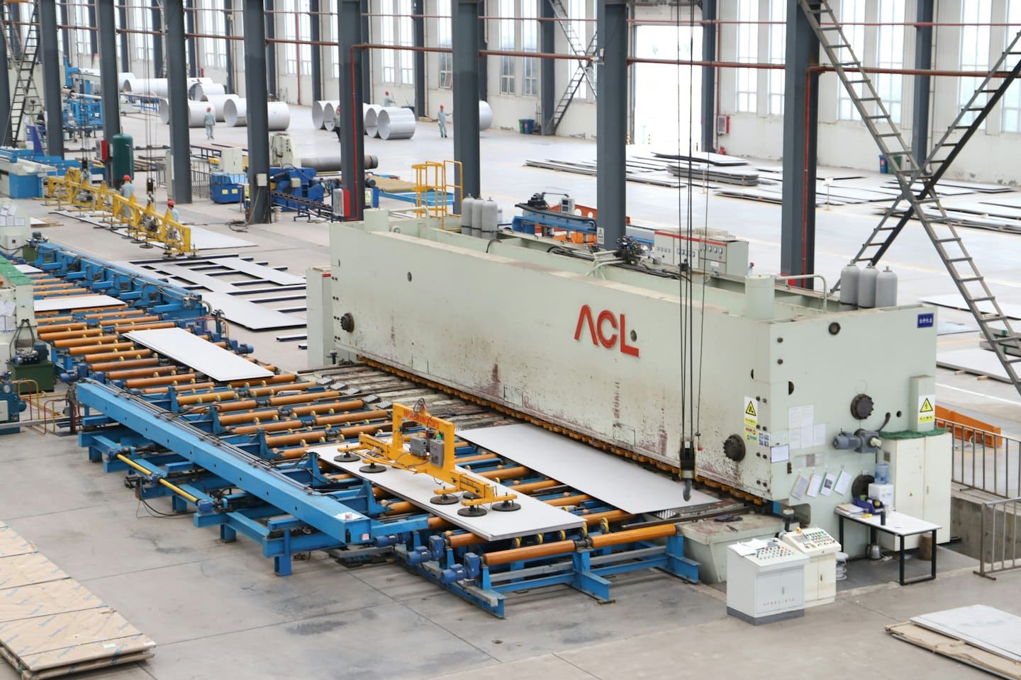 Macchinari automatizzati lavorano lamiere in una fabbrica.